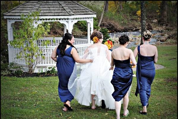 Bride Kelly Matticola navigating muddy terrain(hence the flipflops) to get to a gazebo, but I love the spirit of friendship captured here. October 2011