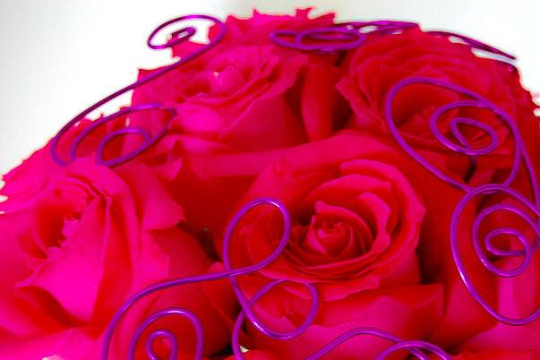 A simple bouquet of shocking pink roses, with few twists of the purple decorative wire, turns into an inventive floral design.