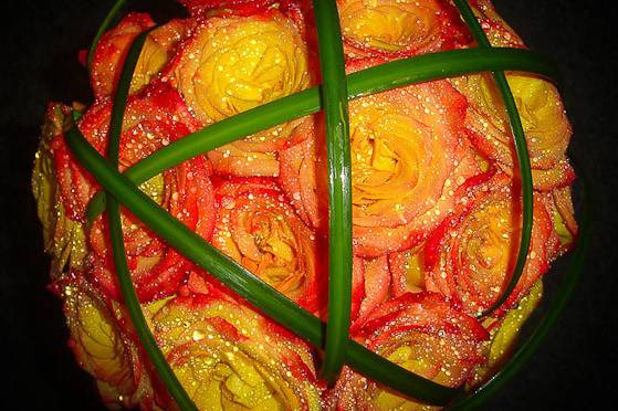 A colorful cluster of circus roses crisscrossed with green lily grass.