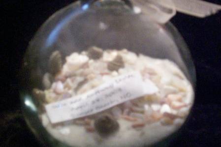 Layers of sand, crushed shells, and miniature shells. Message has bride and groom name with wedding date.