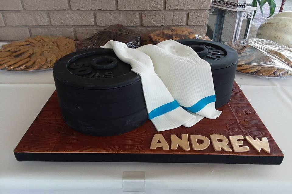 Groom's cake, stack of weight plates with fondant towel and fondant covered board.