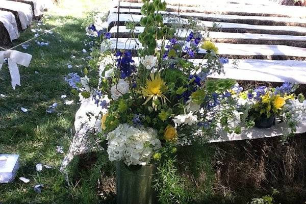 Wedding arrangement of Hydrangeas, Spider mums, Delphinium, Bells of Ireland, Roses, and mixed greens