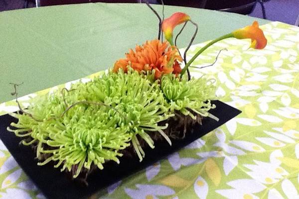 event centerpiece of green Spider mums, orange Dahlias,orange Calla Lily, and curly willow