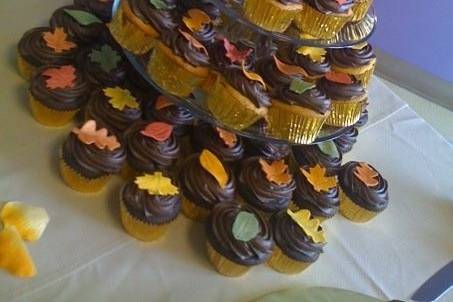 Cupcakes with chocolate buttercream and gum paste leaves  with metallic accents. Top tier covered in fondant leaves with metallic accents.