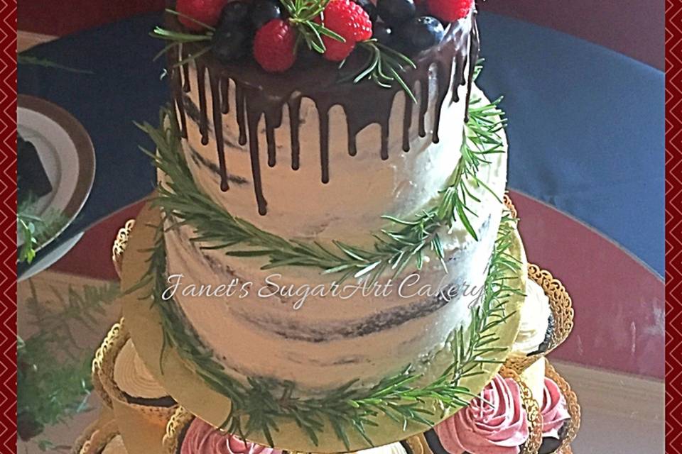 Semi-naked cutting cake with organic berries and a yummy dark chocolate ganache drip. Fresh rosemary around each tier adds to the natural look.