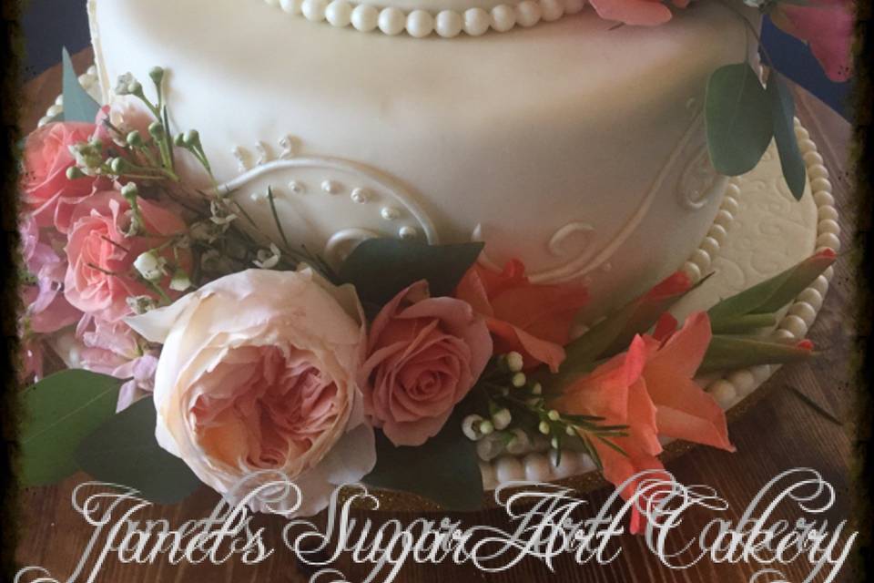 Perfectly crafted scrolls line the sides of this ivory fondant covered cake. Flavors for this bride were cinnamon roll and marble.