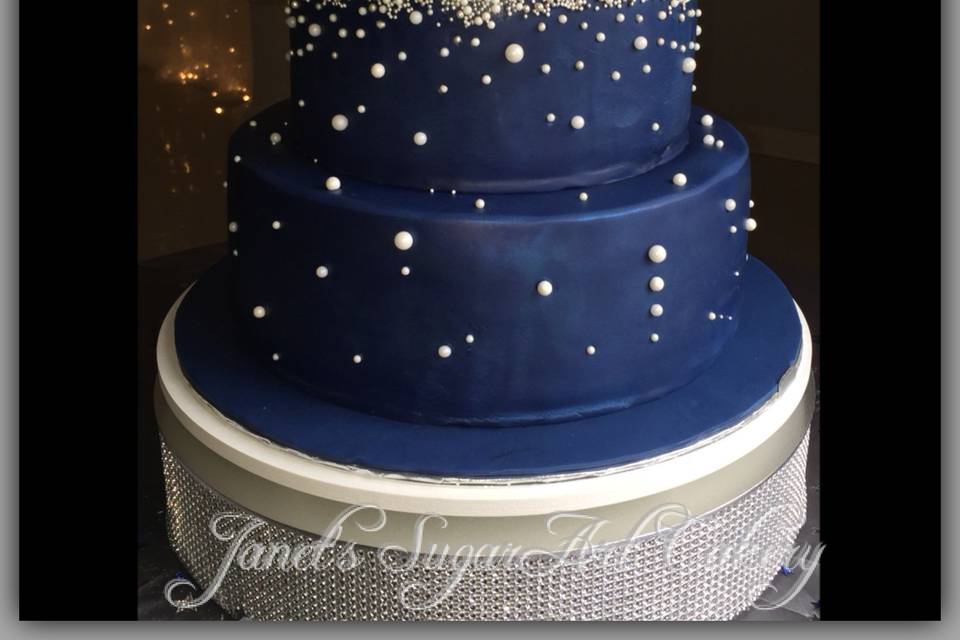 Starry Skies - Silver and white pearls adorn this midnight blue cake. Touches of shimmery dusts help bring the sky to life.