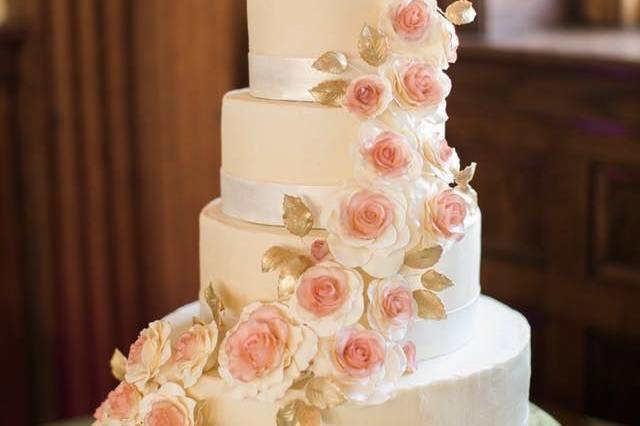 Super smooth buttercream cake with handmade sugar gumpaste roses and golden leaves and a beautiful satiny edible ribbon  for this 4-tier wedding cake