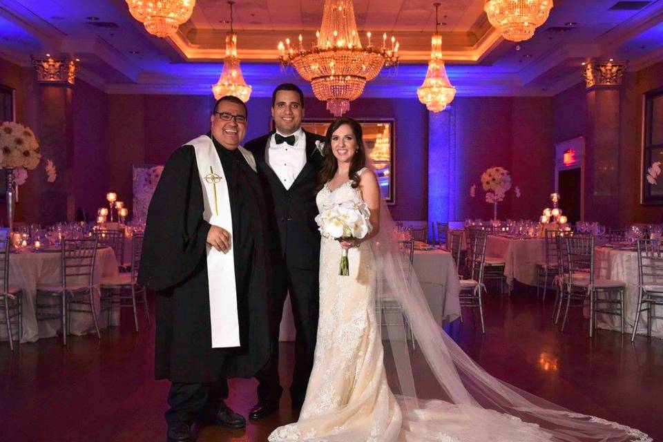 Officiant and the newlyweds in the reception hall