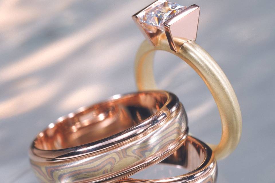 Solid metal engagement ring with mokume wedding bands