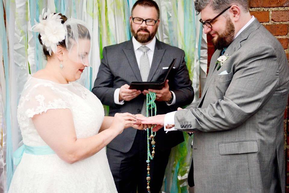 Bride putting the ring on her groom