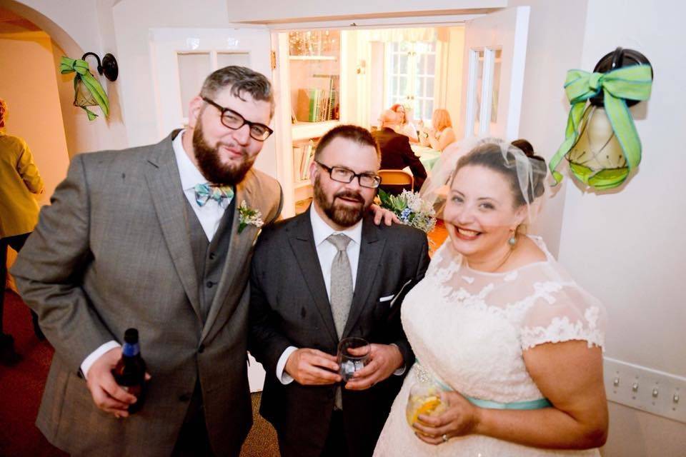 Officiant with the bride and groom at the reception