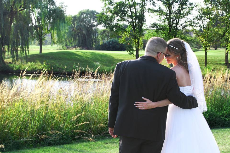 Bride and groom share a private moment on the golf course during wedding reception
