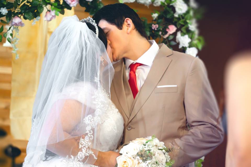 Kiss beneath flower arch