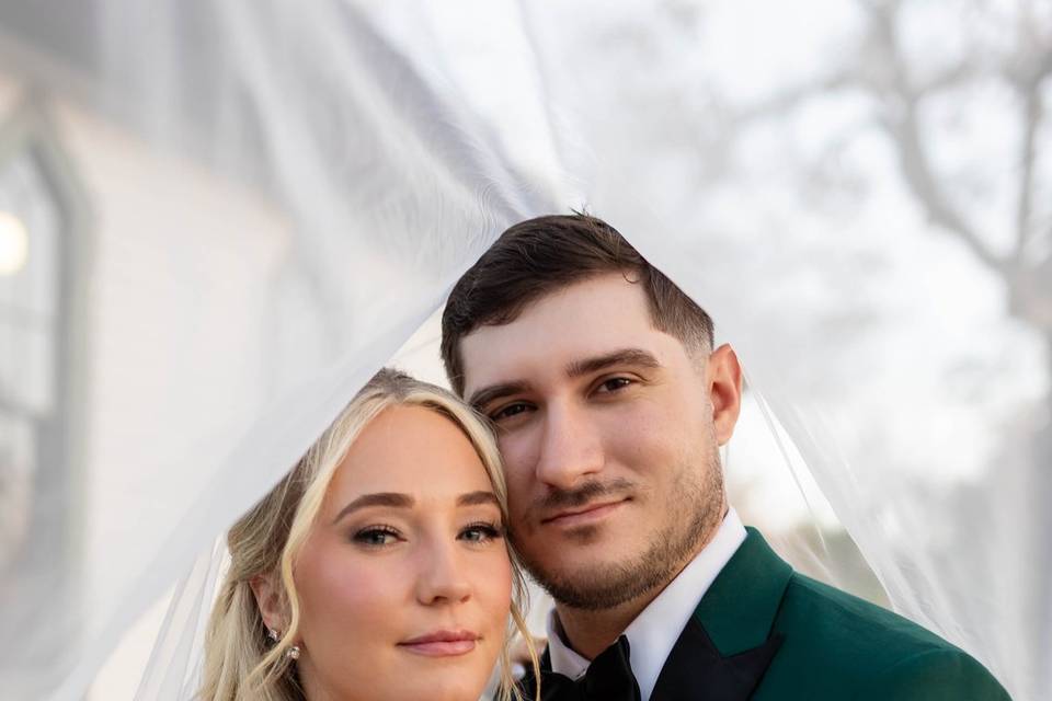 Bride and groom under veil