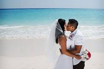 Newlyweds kiss by the shore