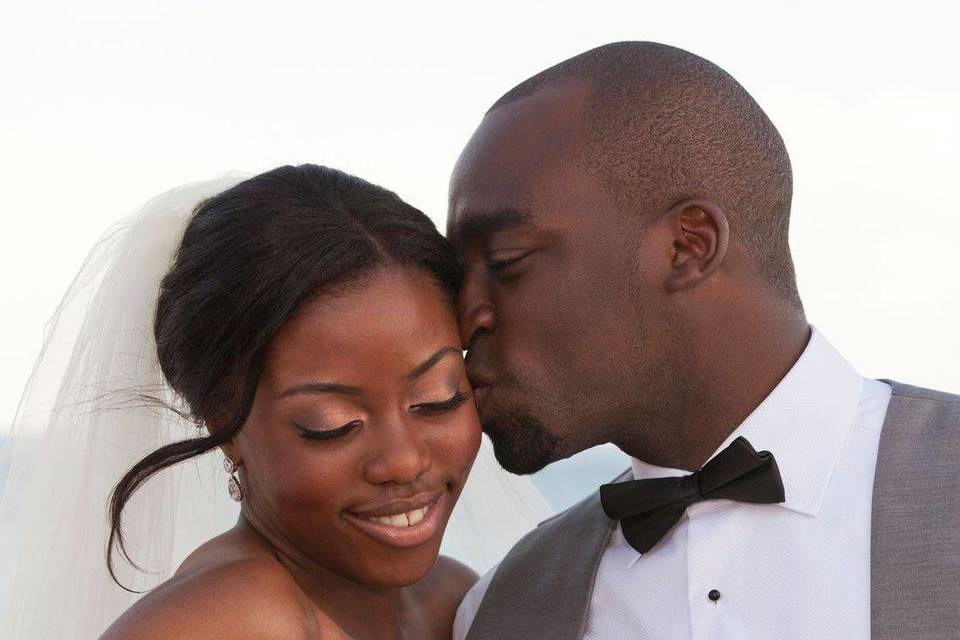 Newlyweds kiss by the shore