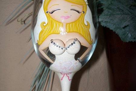 The blushing bride. This bride glass has blonde hair, ivory dress, pink lips and her flowers are white. Rhinestones on the busts. With a custom Mrs. ....... on the back and the date of the wedding. Make it personalize with your hair color, style and length.  Bride is $35