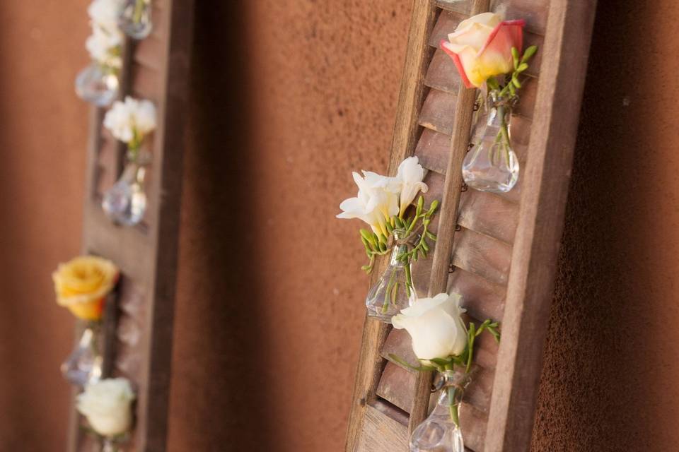 The bride had these old shutters. We used small bud vases and hung them and had a rose bud in each.