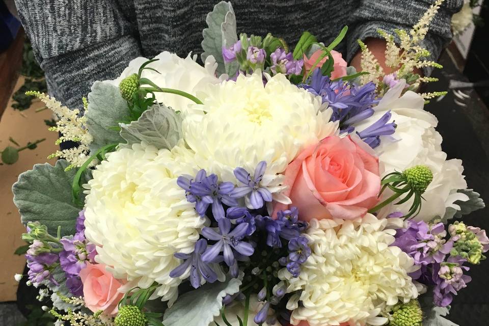 A Casual Lush Bouquet of Peonies, Cremons, Roses, Astilbe, Blue Tweedia, light purple Stock and Dusty Miller.