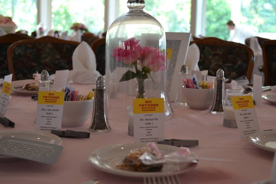 Cassandra Poling Events created the custom table numbers and escort cards for this Disney loving bride! Her centerpieces alternated between this Beauty and the Beast inspired rose under glass, and some more traditional hydrangea arrangements.