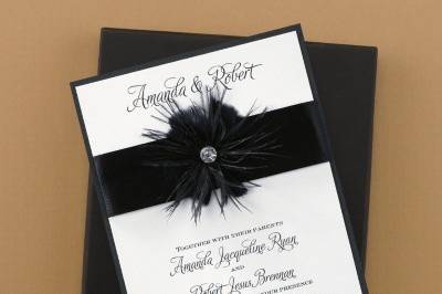 Fanciful Feathers - Invitation: This fully assembled invitation features a white vellum top layer printed with your wording atop a black shimmer base card. The two are wrapped with a ribbon band that is accented with a feather embellishment.
Dimensions: 5 3/4