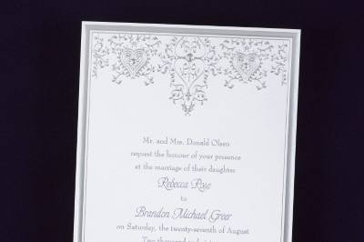 Hearts And Vines - Invitation: A bright white invitation card features a rich silver border with silver heart and filigree design at the top with gold accents.
Dimensions: 5 1/2