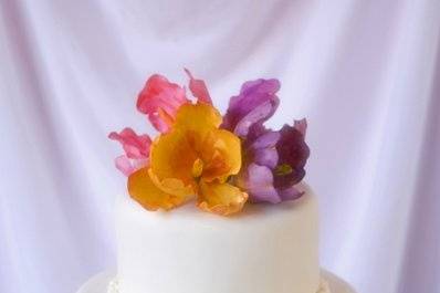 A classic white fondant wedding cake with hand-sculpted sugar tulips and roses.