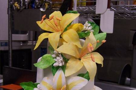 The petite 3-tiered vanilla cake was perfect for just the bride and groom! It is a delicious vanilla cake covered in white fondant and garnished with hand sculpted and hand painted sugar lilies and tulips.