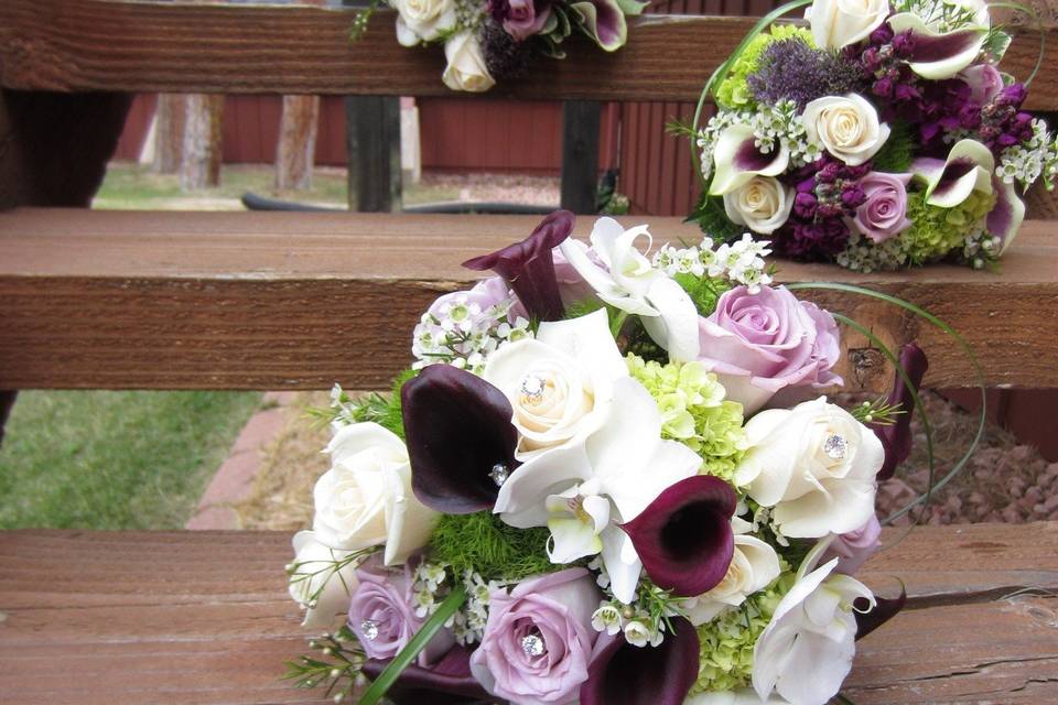 Hand tied bouquet of roses, calla lilies, stock, and hydrangea.