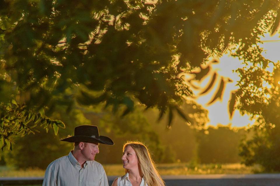 country engagement shoot with sunset. groom has cowboy hat and boots