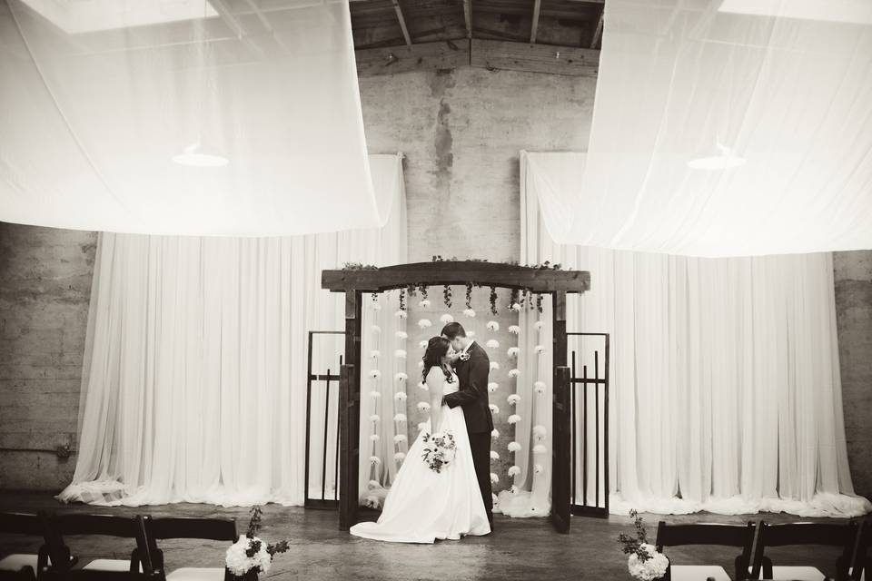 Flower curtain attached to wooden alter arch... along with draping on the ceiling... at The Standard, Knoxville