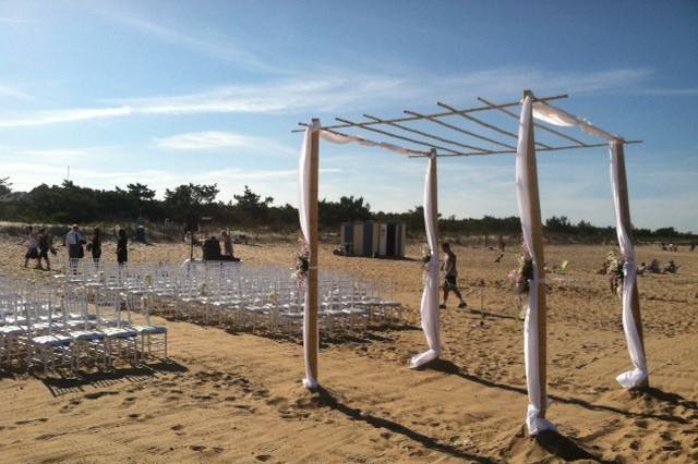 Beach wedding with Large Bamboo Arch and white chivari chairs