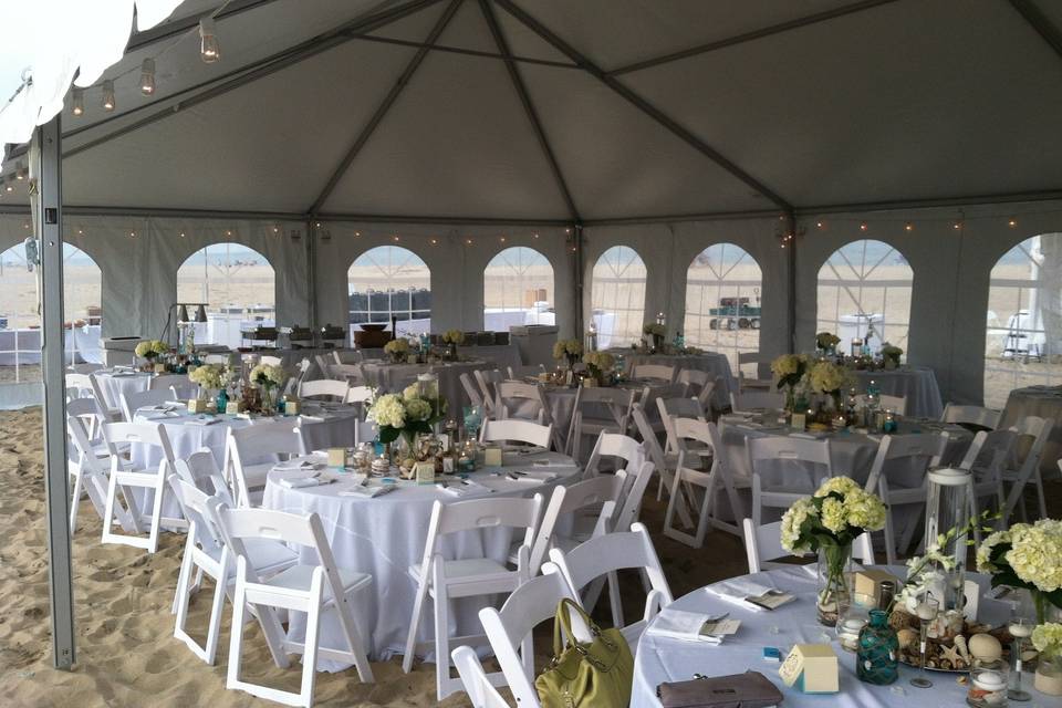 Outdoor tented wedding reception with colored Chinese lanterns & cocktail tables w/ linens