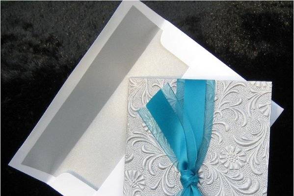 Jay chose this unique silver embossed paper from India and the turquoise satin and organza ribbon to enclose her unique wedding invitation.