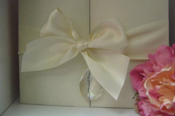 Beauty in an ivory silk box with large satin ribbon in a bow.