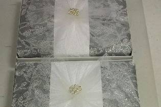 Another creatively wrapped box invitation with fabric-like silver glitter floral paper and tulle with rhinestone and pearl embellishment to top it off.