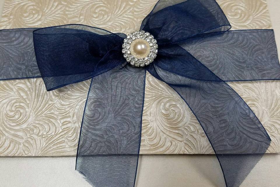 Soft blue chiffon ribbon surrounds this ivory swirl paper from Thailand.