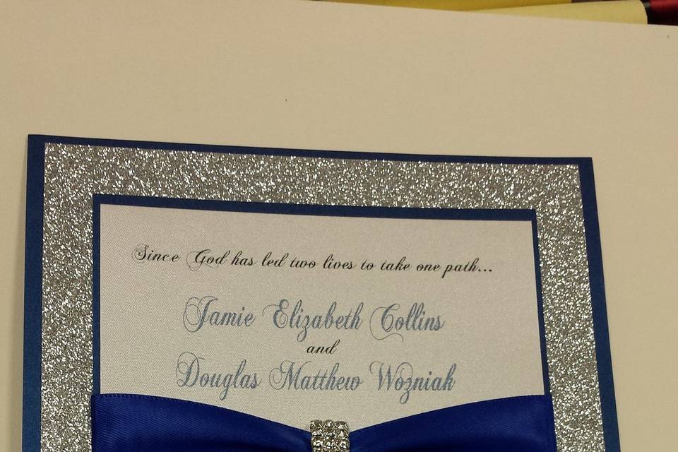 Navy blue accents and silver glitter paper, satin ribbon and rhinestone buckle make for a classy invitation.