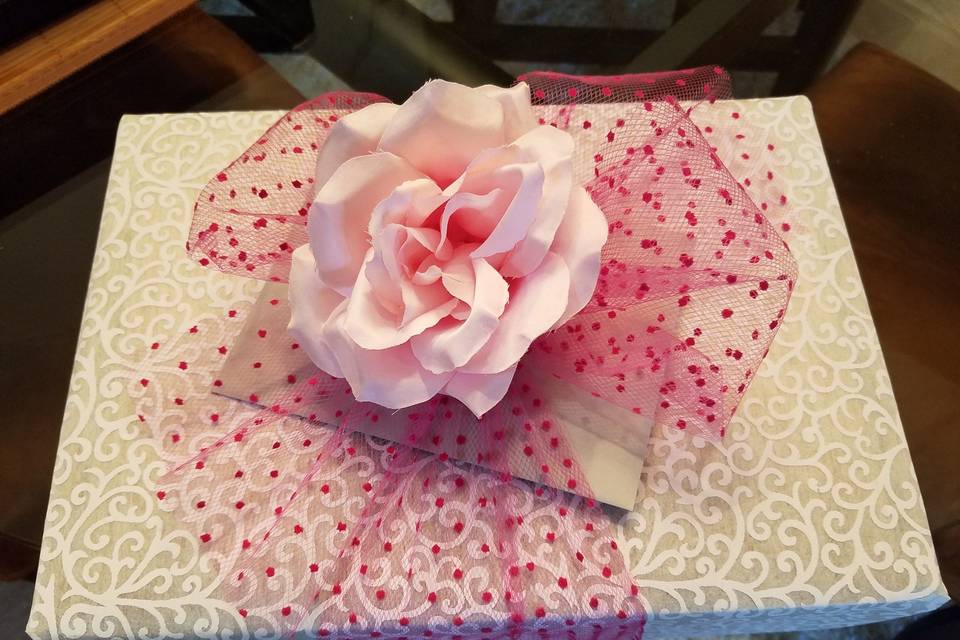 I was asked by the family to wrap their invitation as a gift for someone...I  used a cloth-like paper, pink dotted tulle, and this great flower. Bet they hated to open it...