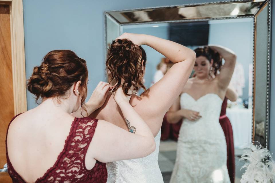 Maid of honor helping bride