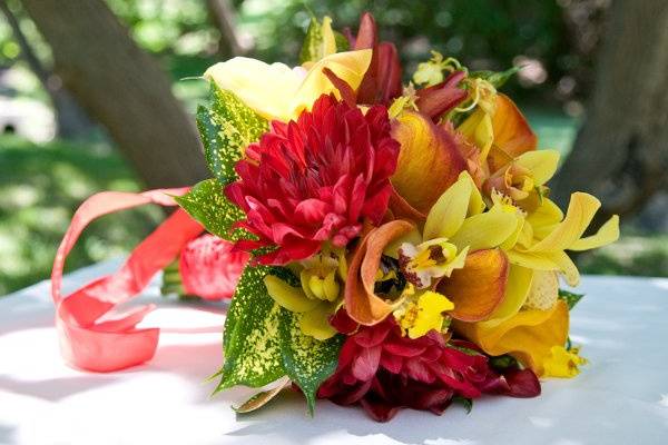 Bright bouquet of callas, orchids, dahlias, and  speckled foliage.