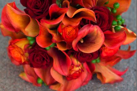 Calla lilies, two colors of roses and berries make up this warm bouquet.