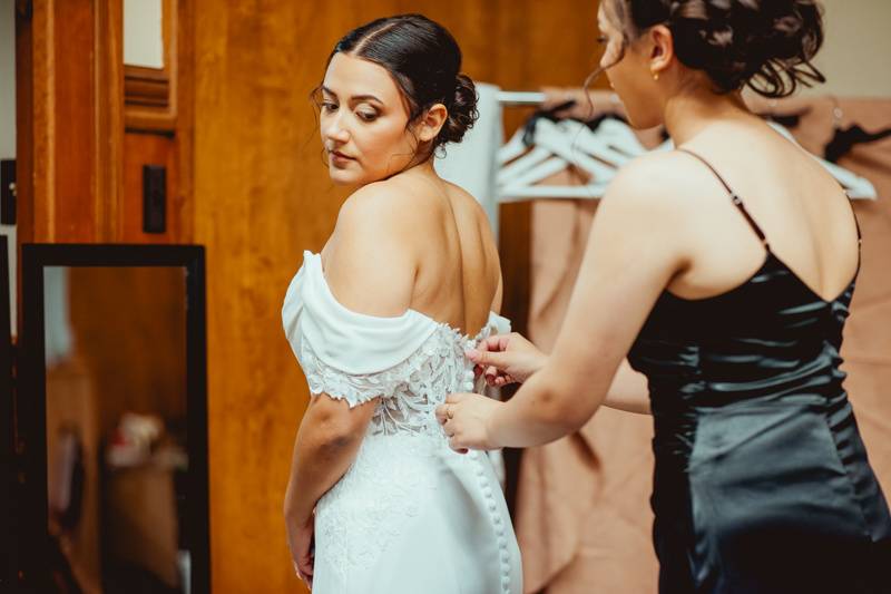 Bridesmaid helps bride