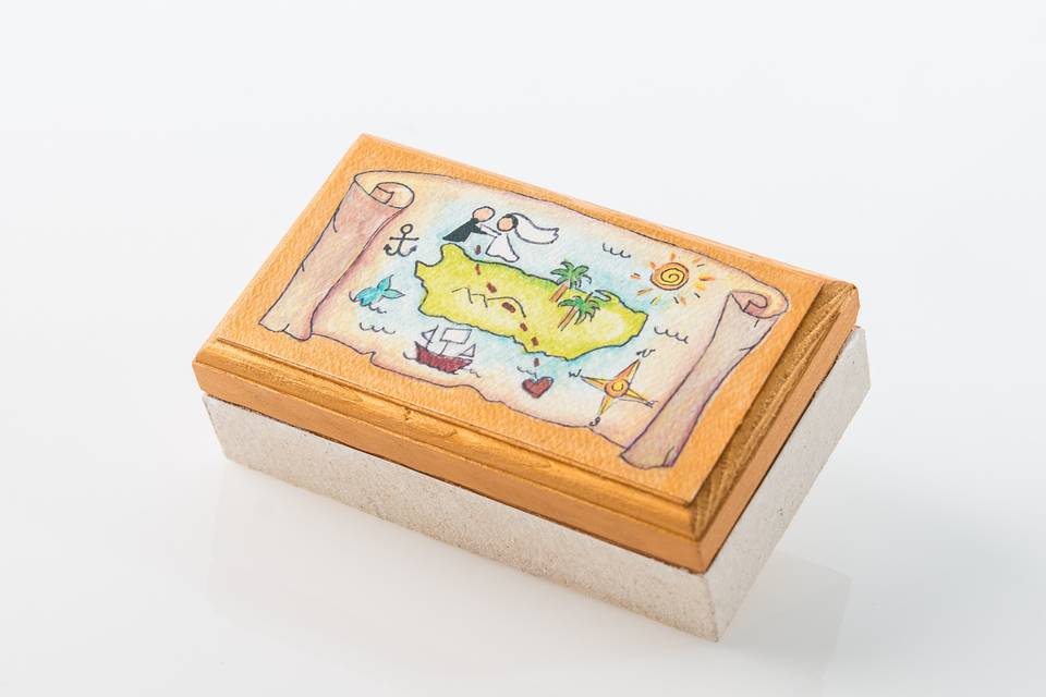 This historical map box is completely hand crafted by a Puerto Rican artist.  It represents the eternal love of two couples who got married in Puerto Rico.  Inside the box you can place a personalized welcome card to your guests or your favorite candies. Box size: 4 1/2W x 1/2L
For more information please contact us at caridadvidroshop@gmail.com
