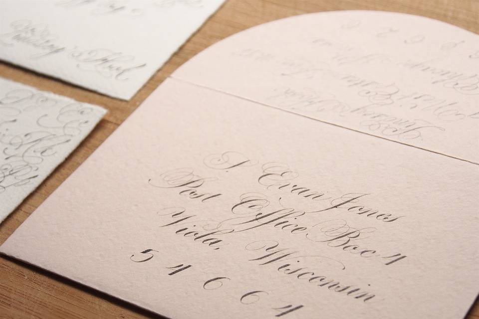 Metallic grey ink in a flourished Copperplate script on a blush pink envelope