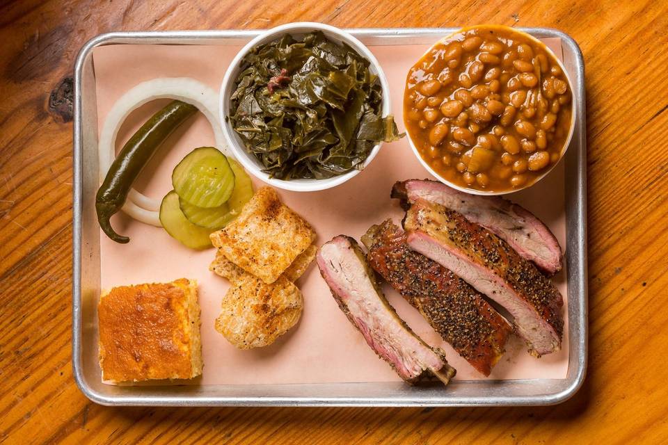 Pork spare ribs, collard greens, baked beans, pickles and peppers and a slice of cornbread