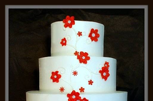 Buttercream with red gumpaste flowers and buttercream scrolls.