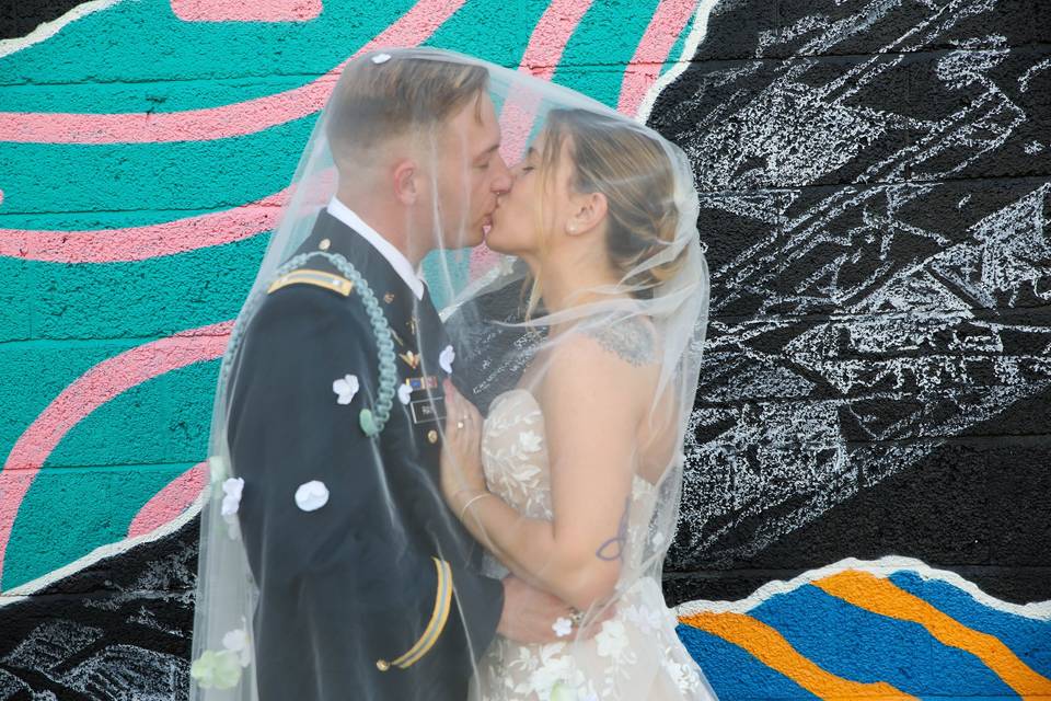 Kiss against art mural