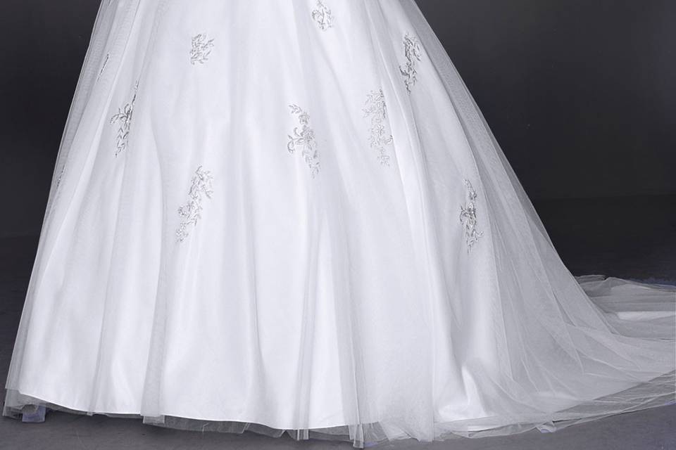DaVinci Bridal Style #: 50267
Tulle ball gown features a V-neckline with sheer embroidered straps that extend into a low sheer back.  Bodice is accented with embroidered appliqué that scatter throughout the skirt.  Chapel length train and zipper back.